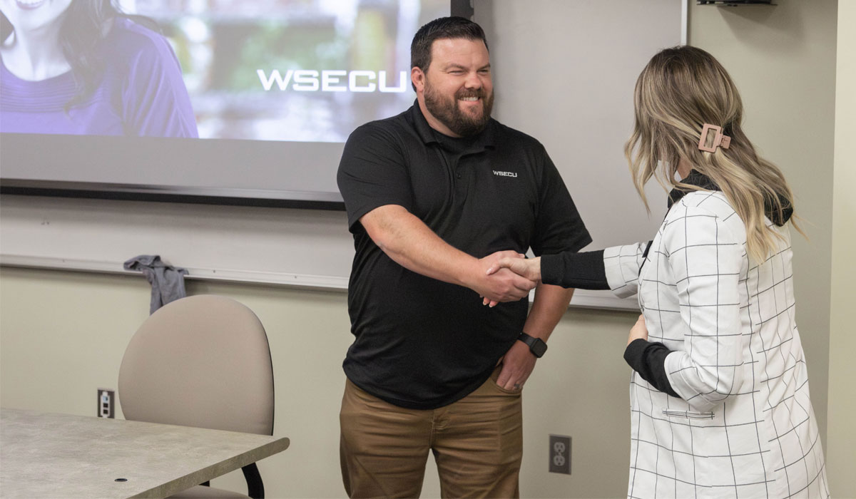 YVC professor shakes hands with guest speaker. 