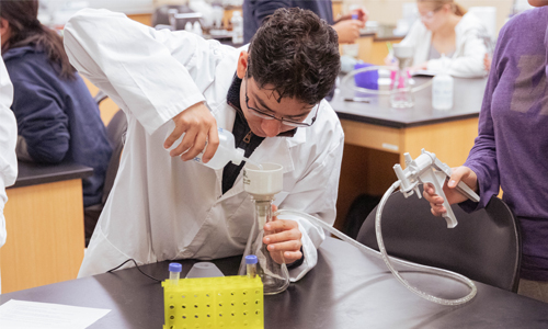 Biology student measures out liquids during his lab. 