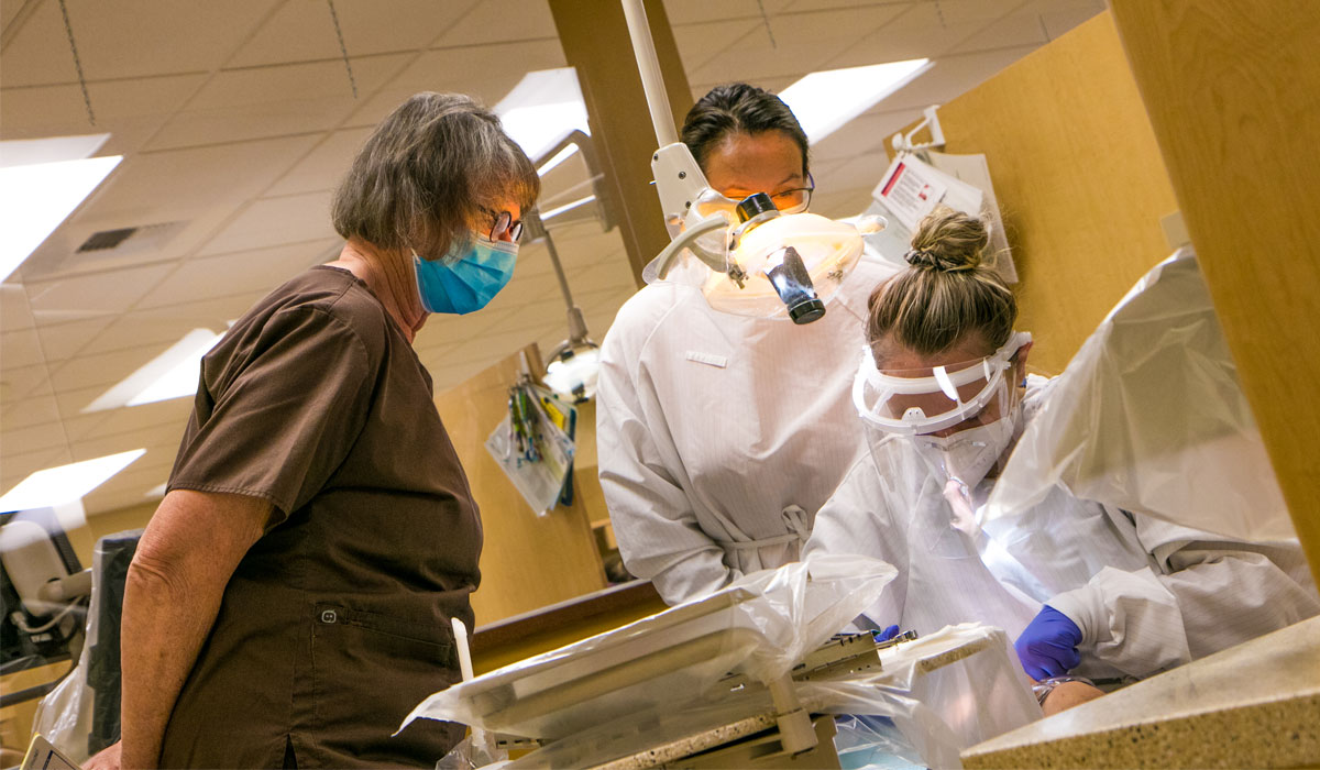 YVC dental professors looks on as YVC student performance dental procedure. 