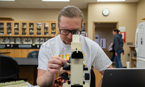 YVC student looking throught microscope