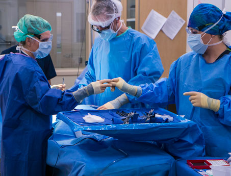 Group of surgical techs works with doctor during a surger. 