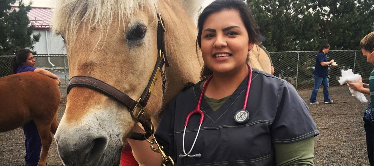 Vet Tech poses for picture with horse. 