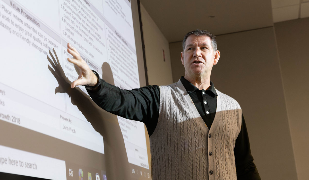 Instructor points to the screen during a lecture.