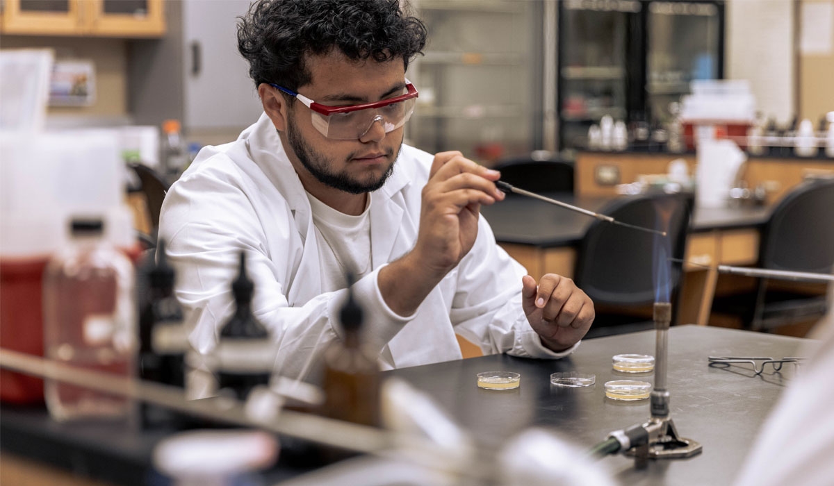 Student works on a STEM lab assignment using a flame. 