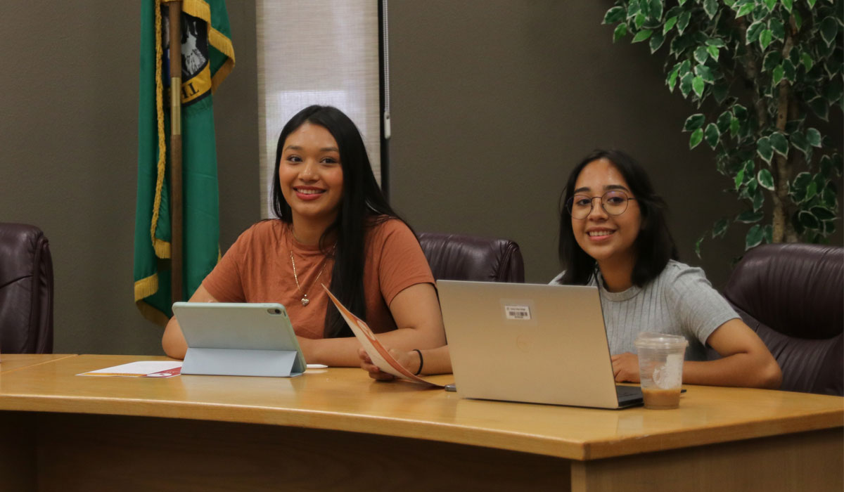 Two members of Student Council sitting at the front table during the meeting. 