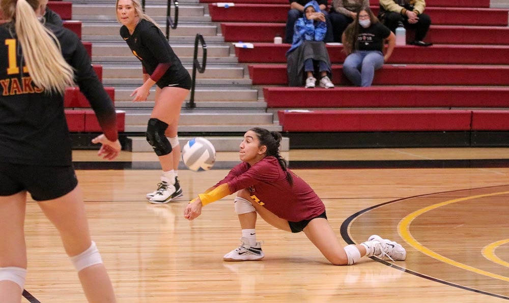 Female volleyball player digs ball