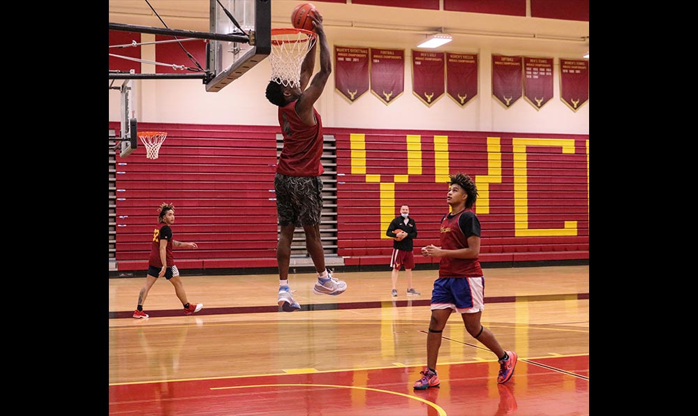 Male basketball player dunking