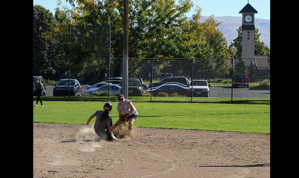 Softball player sliding to base