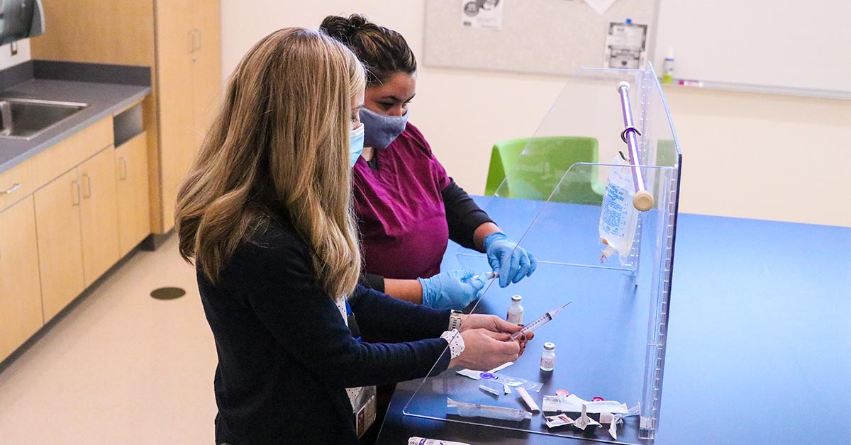 Student and instructor prepare syringe