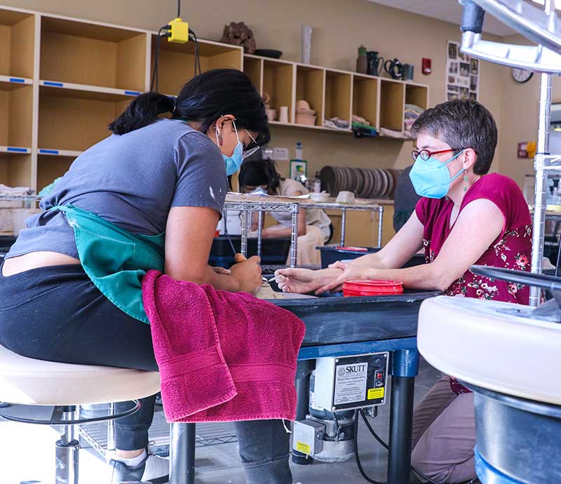 Rachel Dorn works with student in classroom