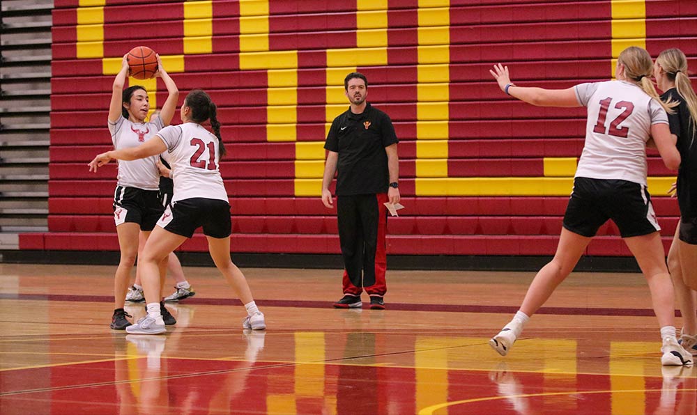 Women's basketball players and coach in practice