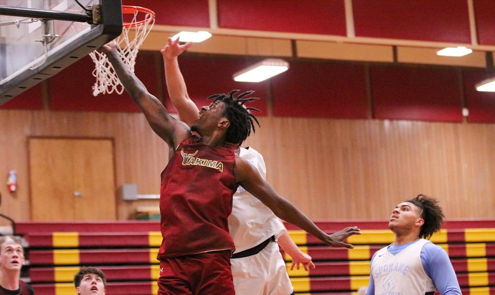 Male basketball player attempts layup