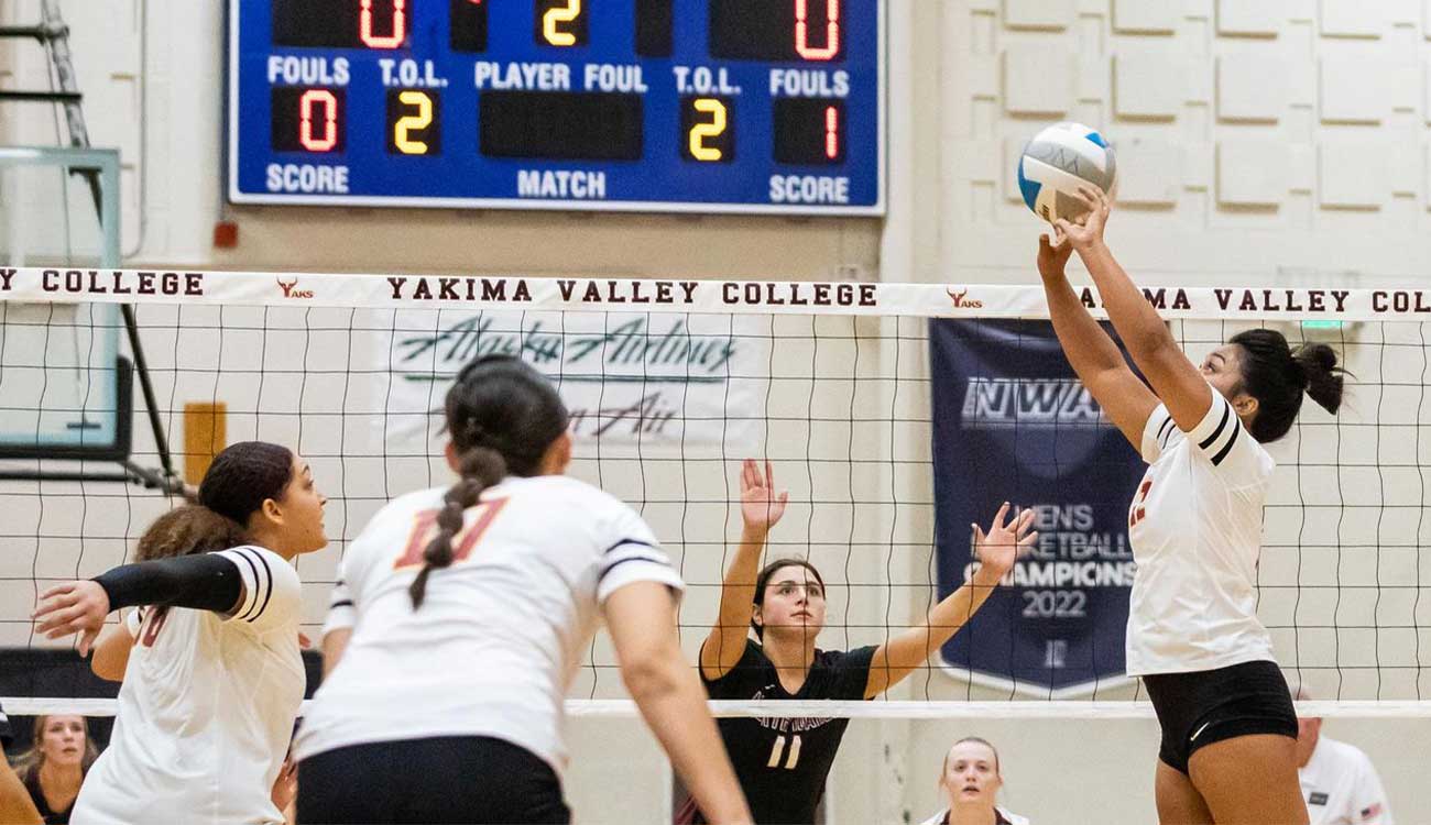 Volleyball player sets ball to teammate during game. 