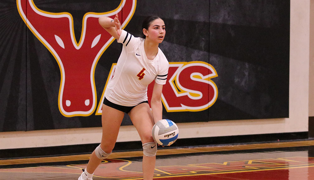 Female volleyball player prepares to serve