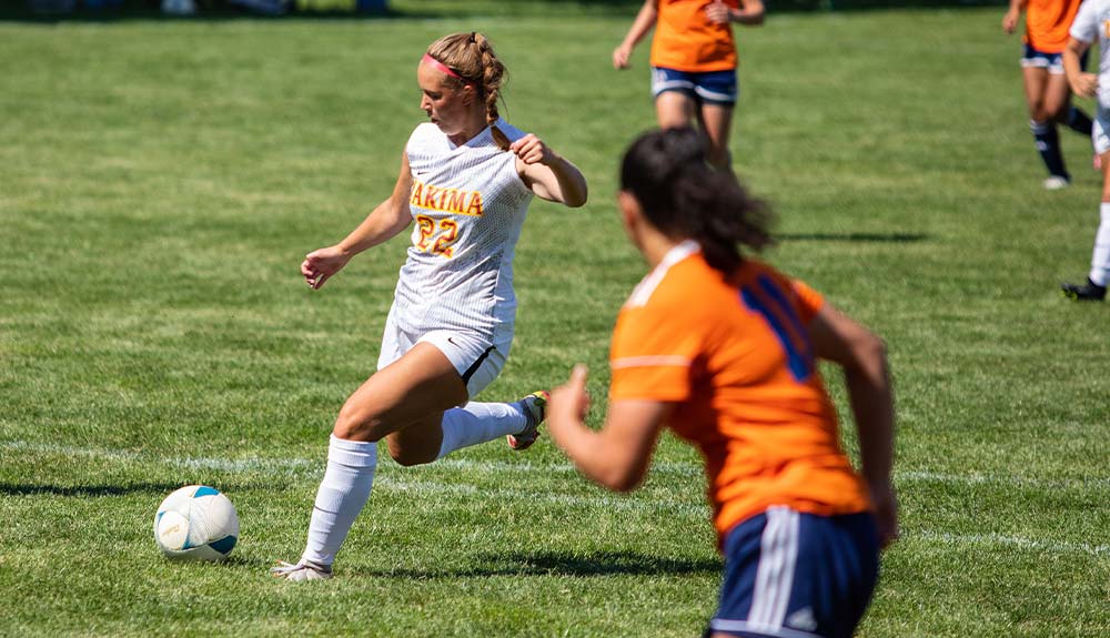 Female soccer player prepares to kick ball