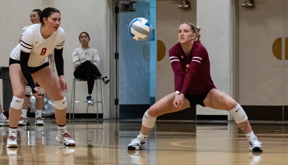 Female volleyball player digs the ball