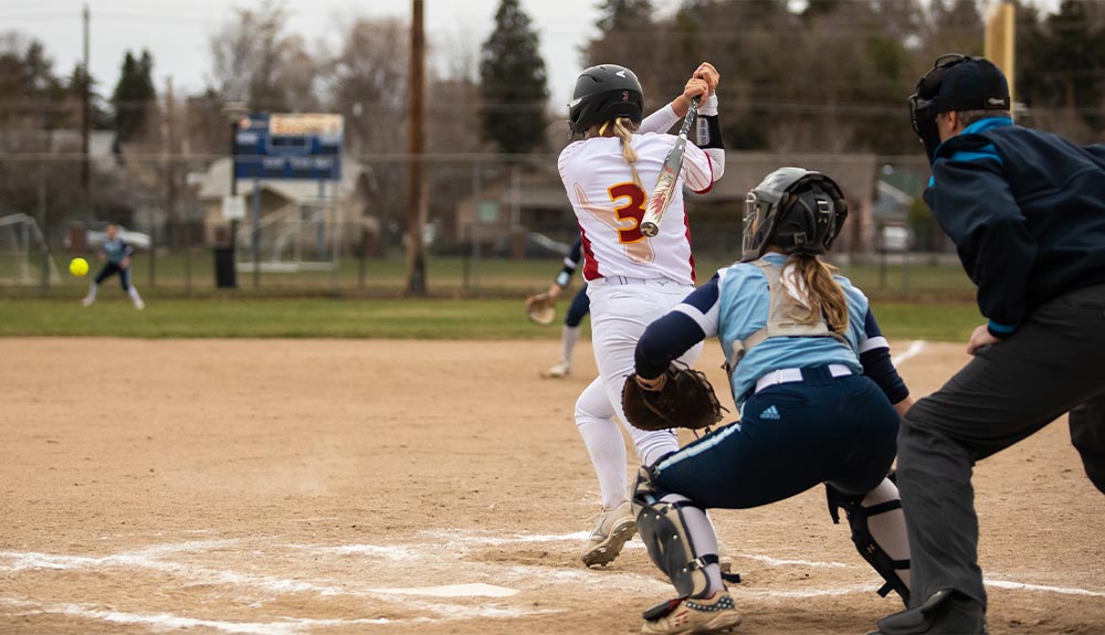 Softball player hits ball