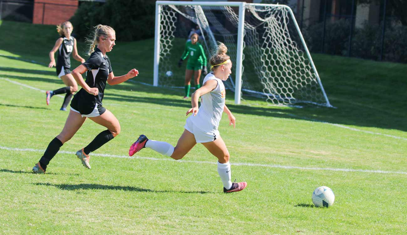 Women's soccer player with net in background