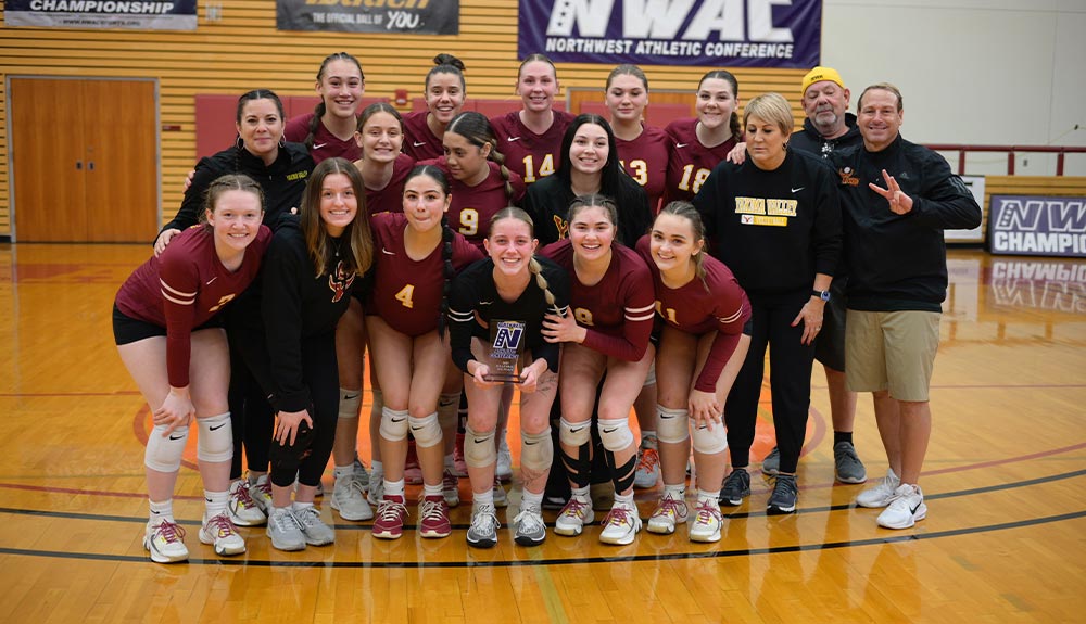 Volleyball players pose with trophy