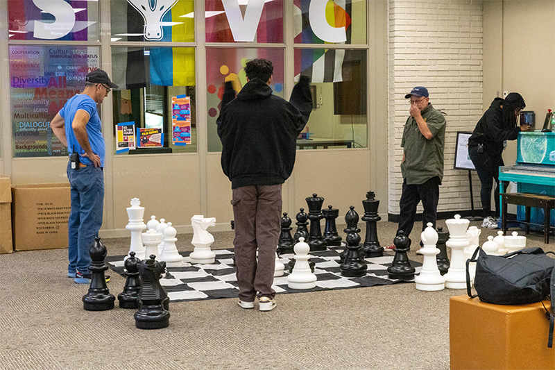 Staff play chess on oversized board