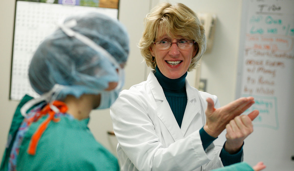 Sue Wedam talks to a student during a surgical lab