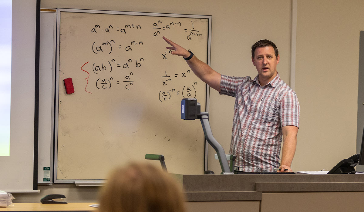 YVC Math Instructor Matt Lewis explains math problem to class using whiteboard