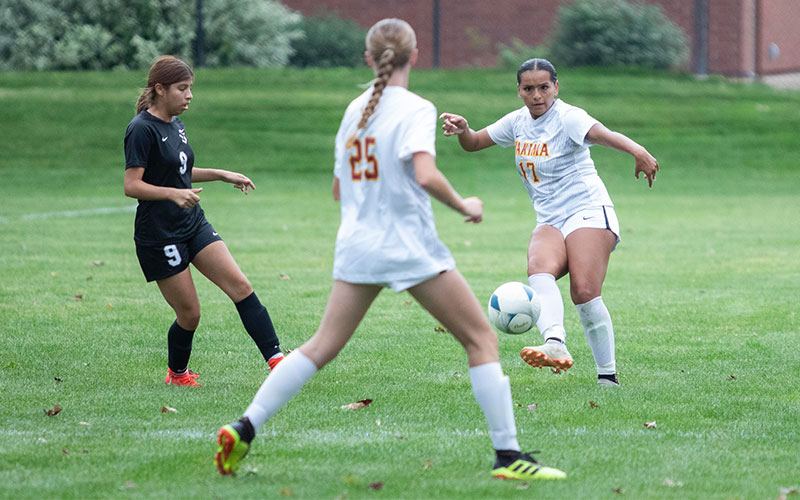 Yakima Valley College women's soccer player passes ball to teammate