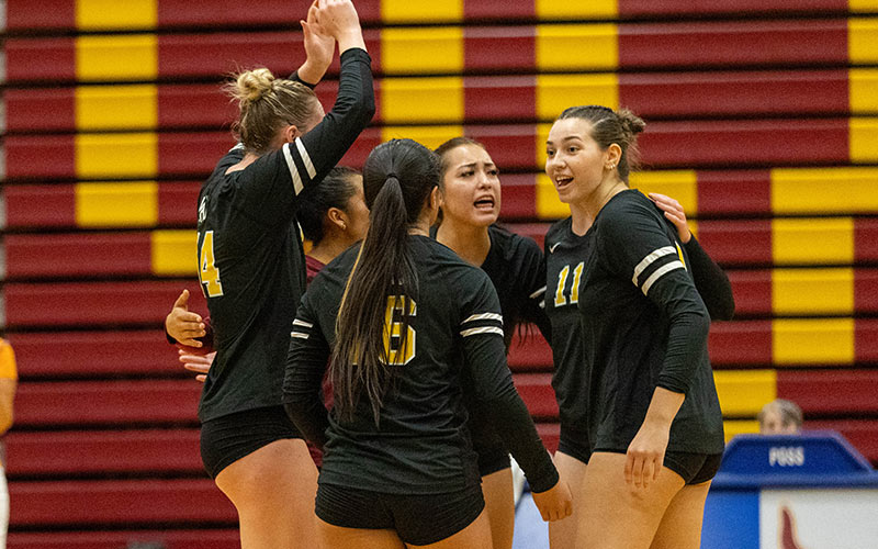 YVC volleyball players celebrate after scoring point