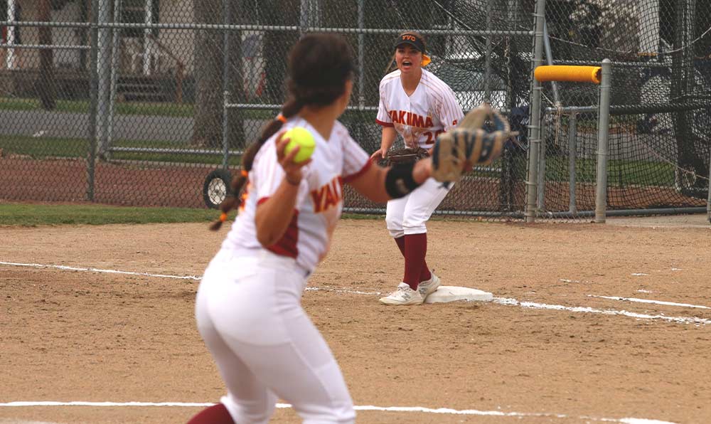 Softball player throws to first base