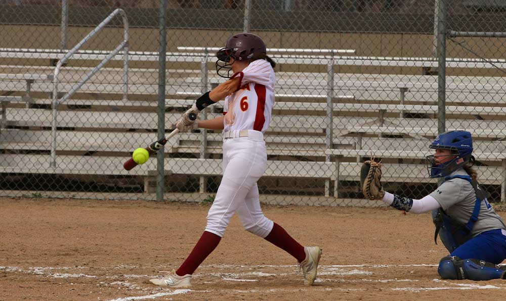 Softball player hits ball