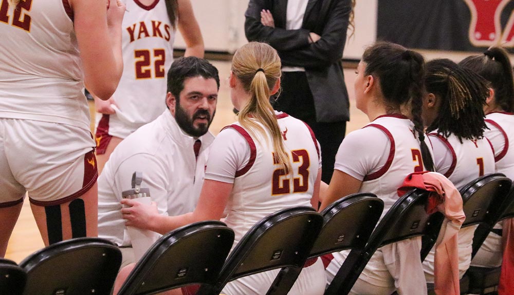 Coach talks to women's basketball players during timeout