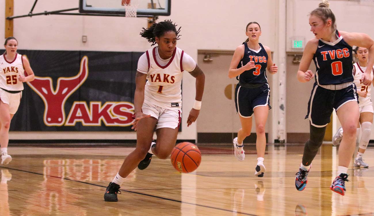 Women's basketball player dribbles in open court