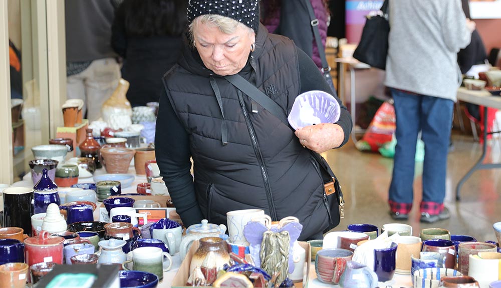 Woman looks at pottery