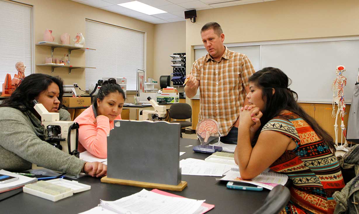 Instructor Jeremy Buegge talks with student during class. 