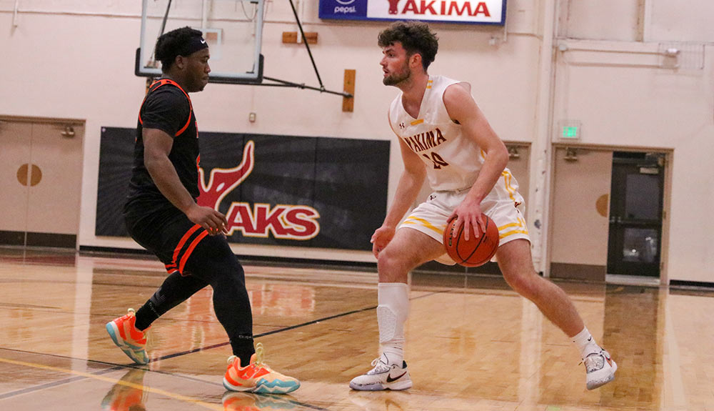 Male basketball player dribbles in front of defender