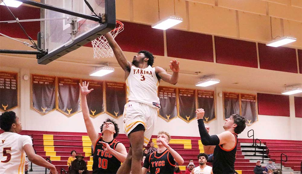 Male basketball player attempts layup