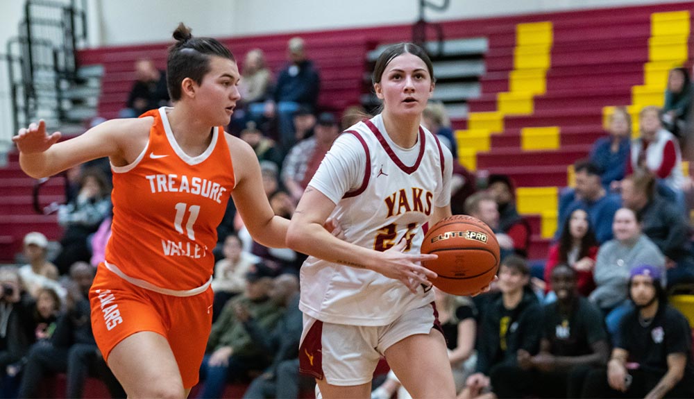 Female basketball player dribbles past defender