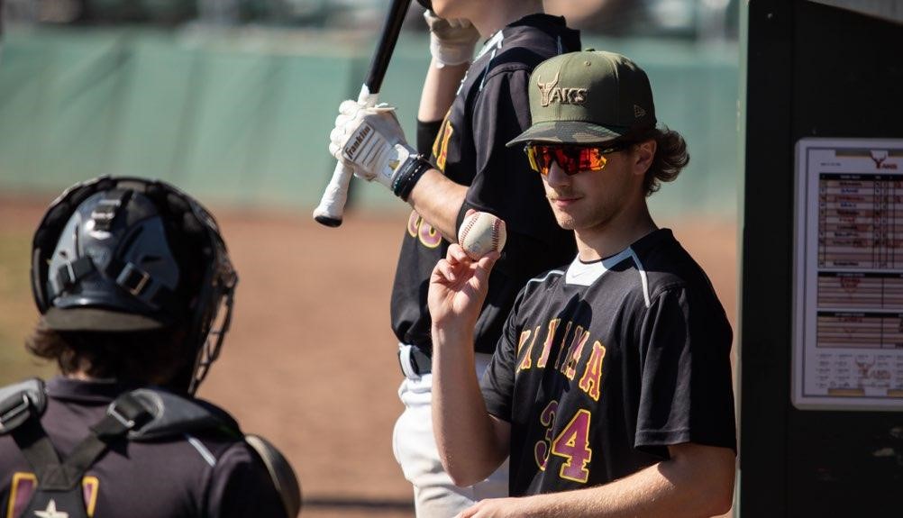 Baseball pitcher talks to catch in dugout