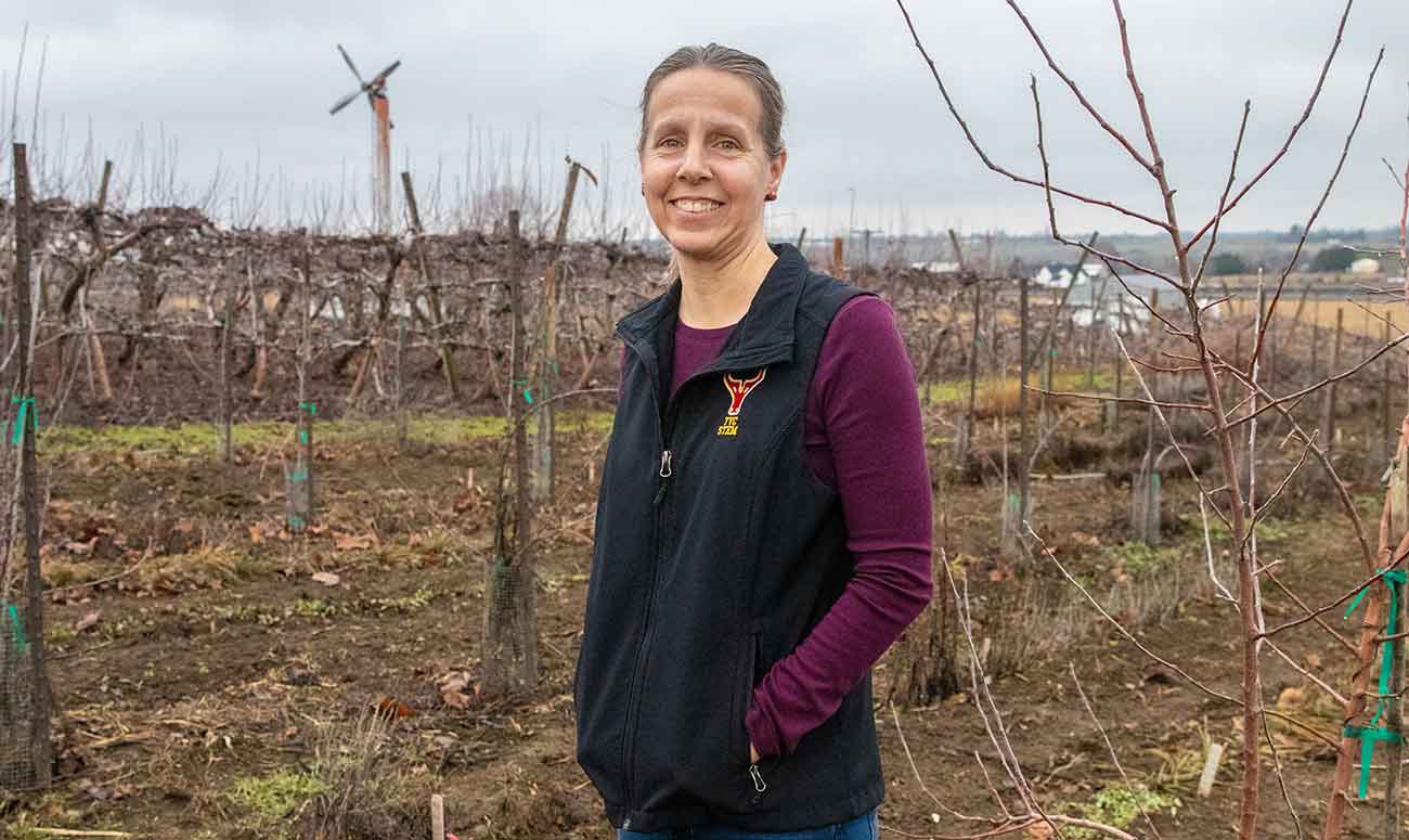 YVC instructor poses for picture with agricultural field in the background. 