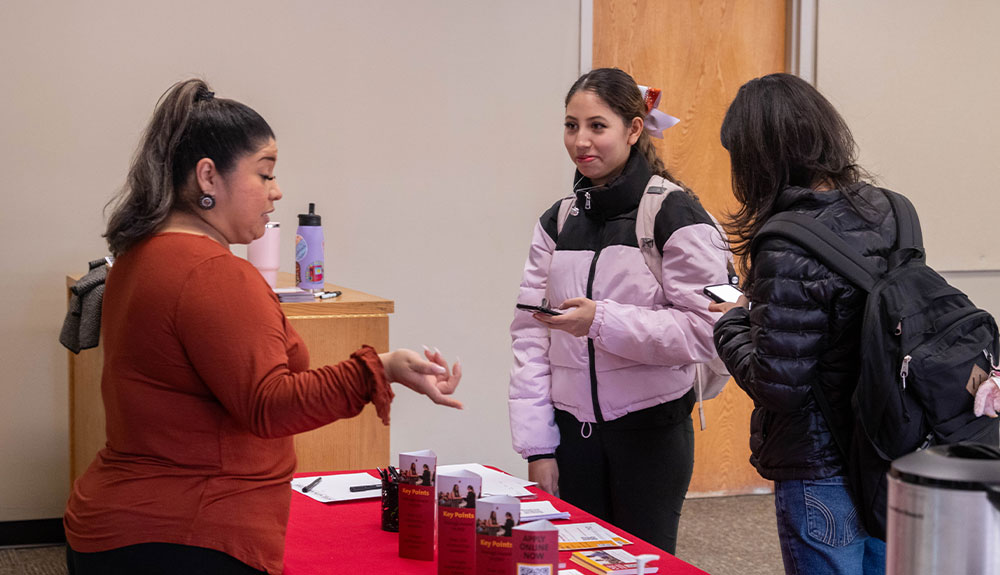 College staff member talks to two students