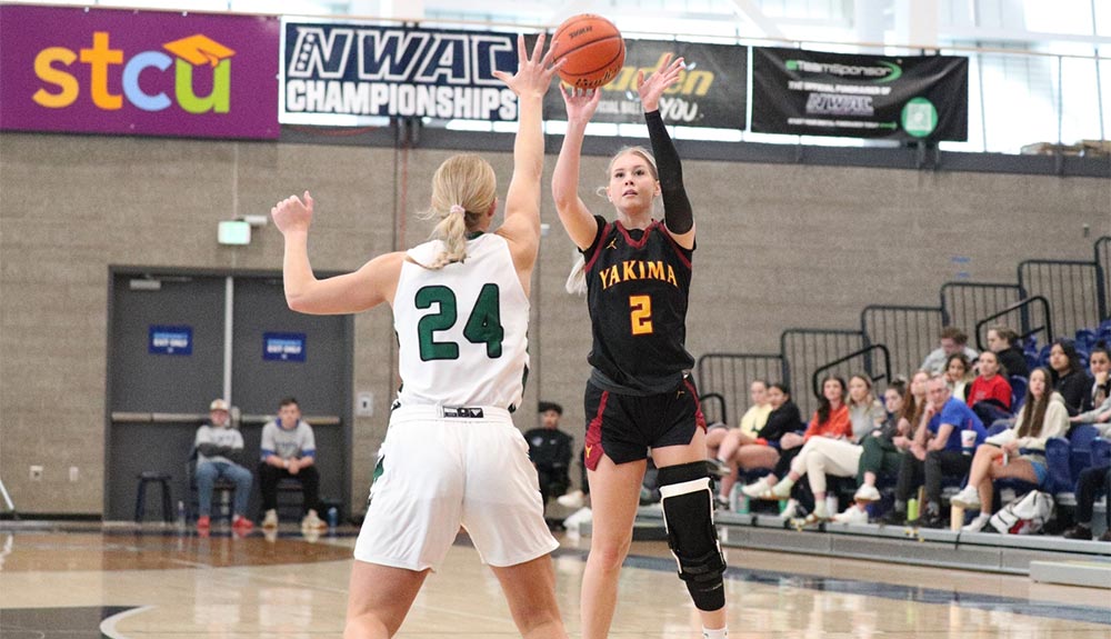 Female basketball player attempts jump shot