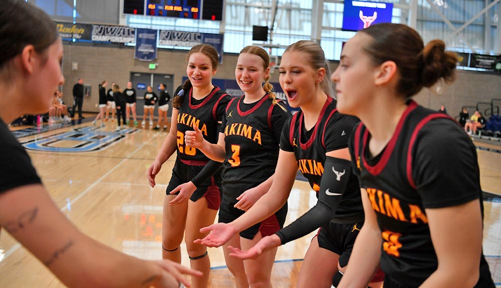 Female basketball players high five one another