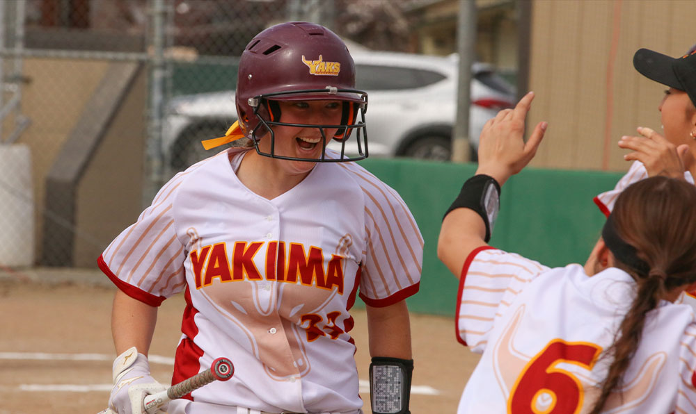 Softball player celebrates with teammates