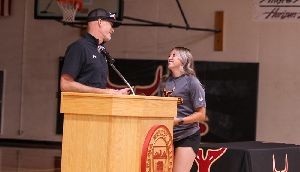 Coach shakes players hand at podium