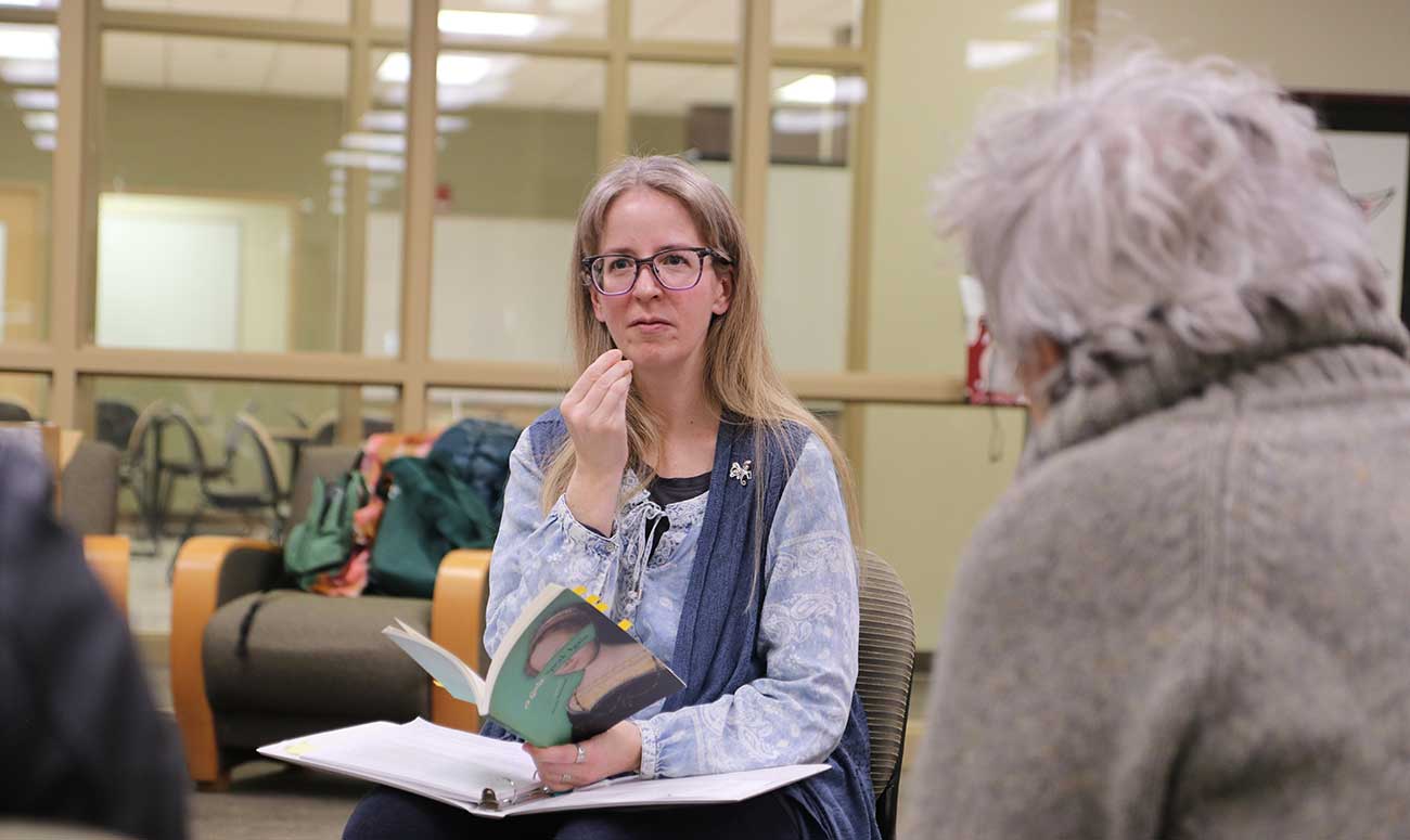 Dayna Patterson speaks with participants during an event. 