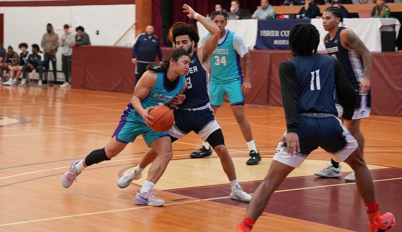 Bryan Strom drives past defender with basketball.