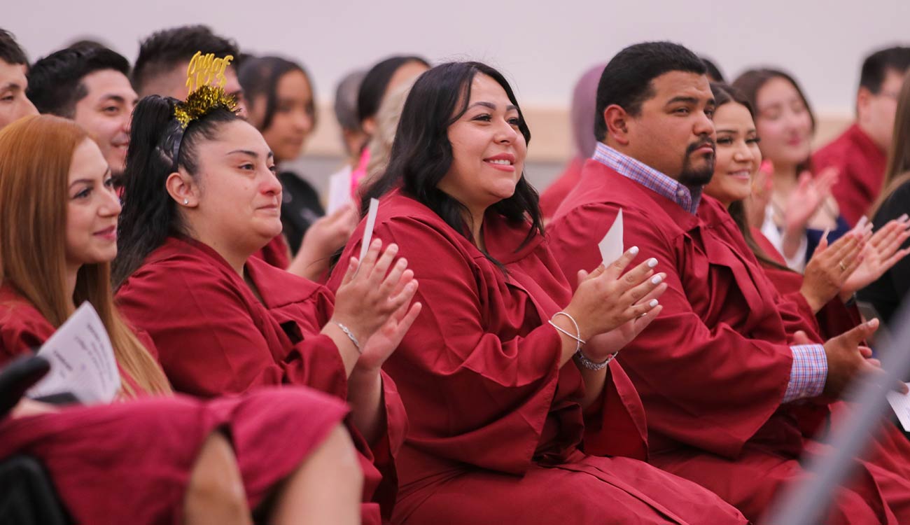 Graduates in robes clap