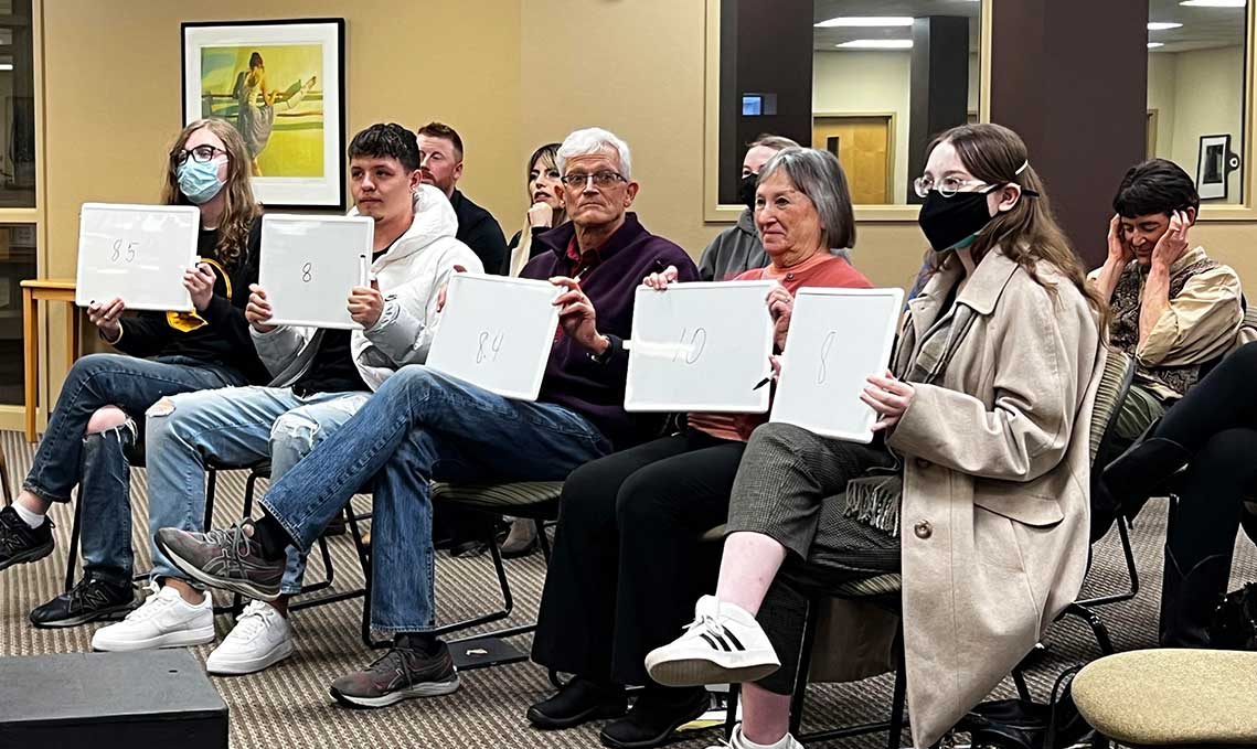 participants rate poets using small white boards. 