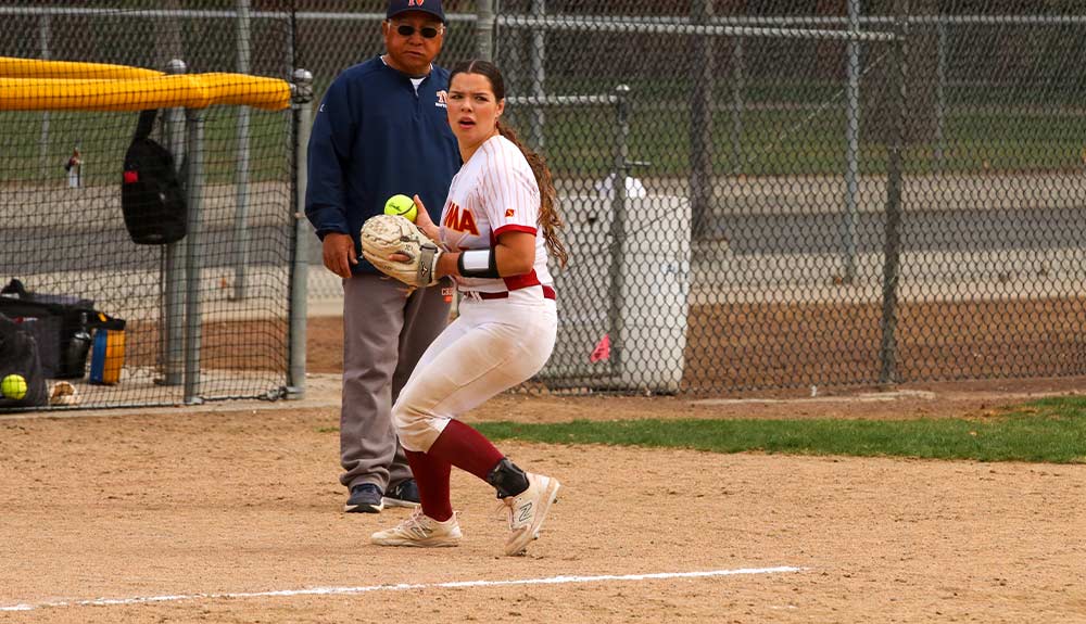 Softball player prepares to throw ball