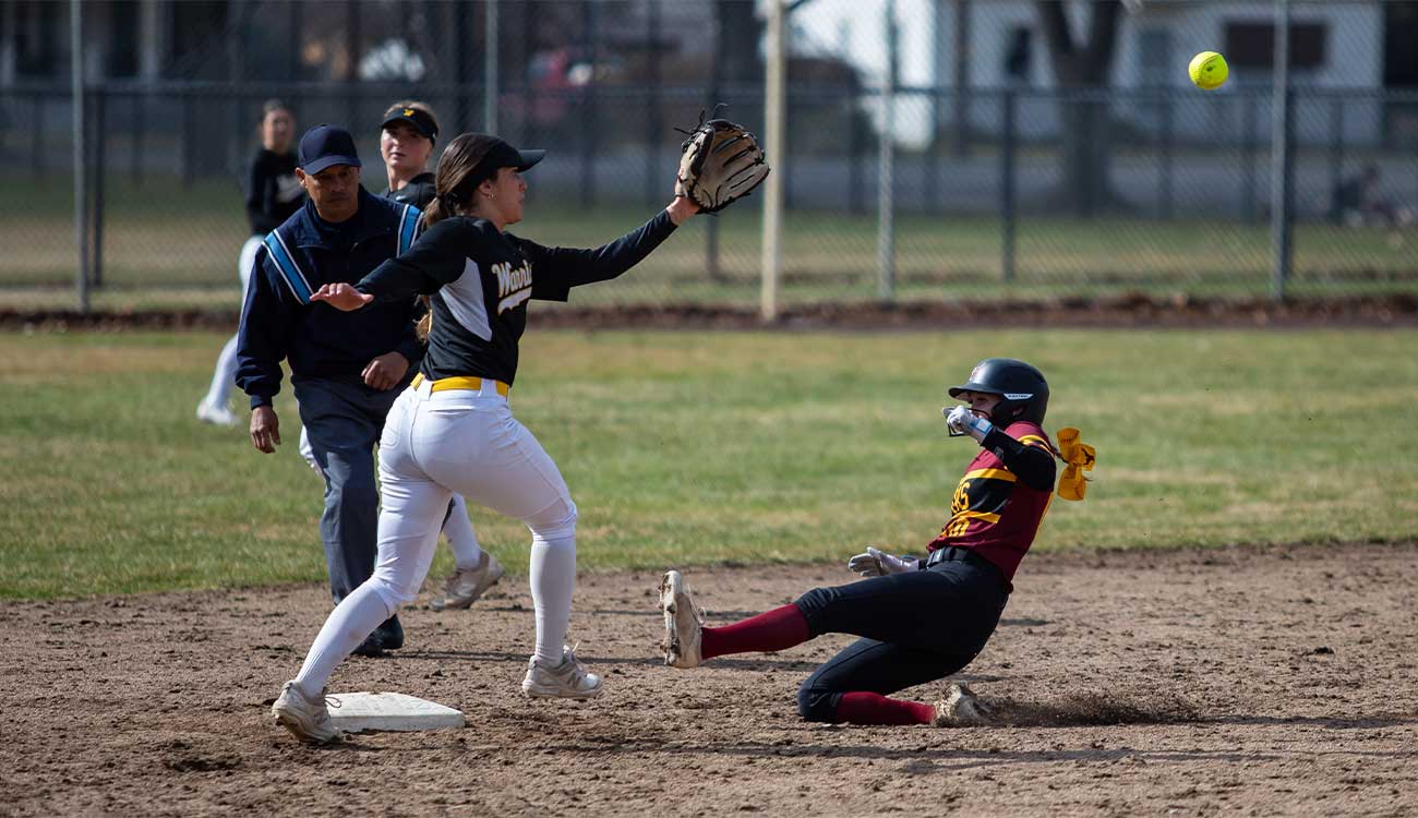 Softball player slides to second base